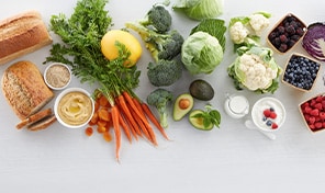 Large assortment of fresh breads, vegetables, fruits, yogurt, grains, and hummus